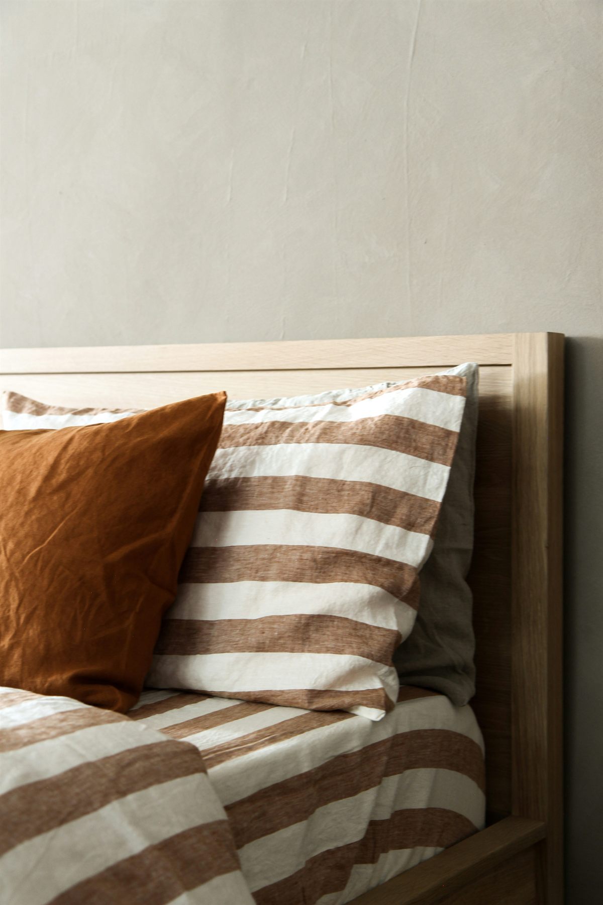 Close-up of freshly laundered striped bed linen on a made bed